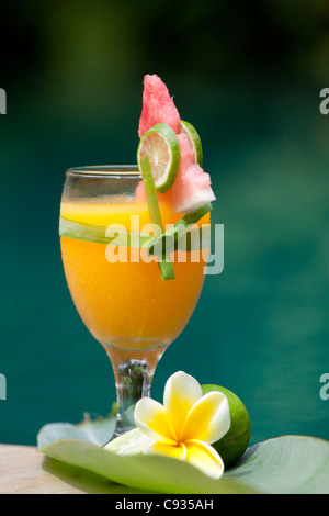 Bali Ubud. Einen frisch gepressten Fruchtsaft mit tropischen garniert durch einen Pool. Stockfoto