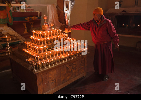Indien, Ladakh, Leh. Auffüllen der Butterlampen mit Öl in die Chamba Lhakhang, ein Schrein für Maitreya, im Leh Palace. Stockfoto
