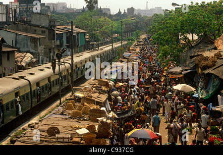 Indien, West Bengal Kolkata (aka Kalkutta). Menschenmassen drängen sich einen Markt direkt neben einer Bahnlinie. Stockfoto