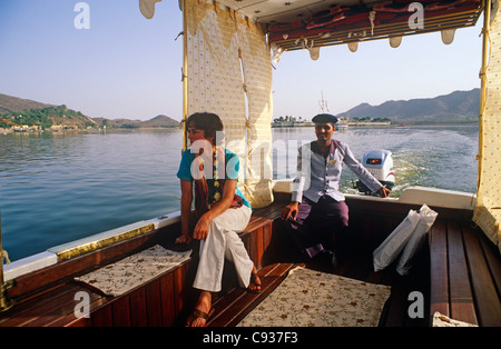 Indien, Rajasthan, Udaipur. Ein kleines Taxi-Boot springt Gäste zum berühmten Lake Palace Hotel am Pichola-See in Udaipur. Stockfoto