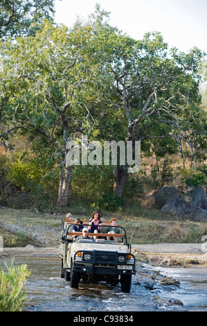 Malawi, Majete Wildlife Reserve.  Familie auf Safari überqueren Sie den Mkulumadzi Fluss in ihrem Safari-Fahrzeug. Stockfoto