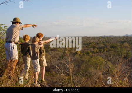 Malawi, Majete Wildlife Reserve. Ein Guide mit Robin Pope Safaris führt Kinder auf eine Familien-Safari auf eine Buschwanderung. Stockfoto