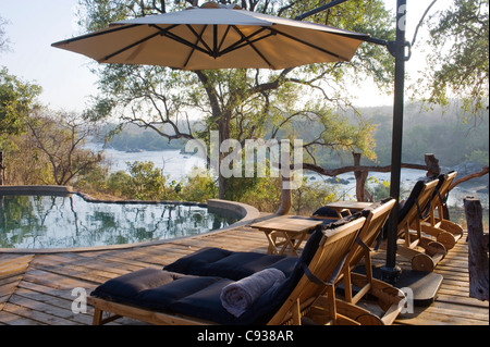 Malawi, Majete Wildlife Reserve.  Sonnenliegen am Pool in Mkulumadzi lodge Stockfoto