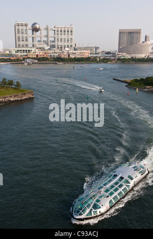 Ein Sightseeing-Boot Heads in Tokyo Bay mit dem markanten Fuji Fernsehen Gebäude hinter. Odaiba, Tokyo, Japan Stockfoto