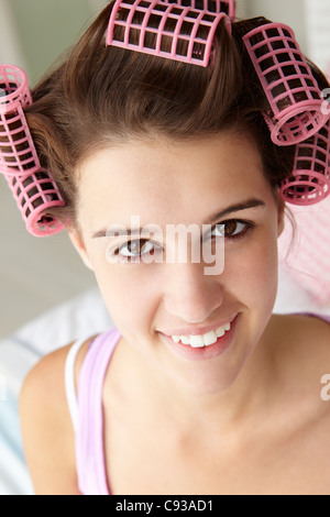 Teenager-Mädchen mit Haaren in Lockenwickler Stockfoto