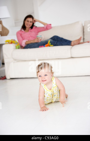 Mutter beobachten Baby crawl Stockfoto