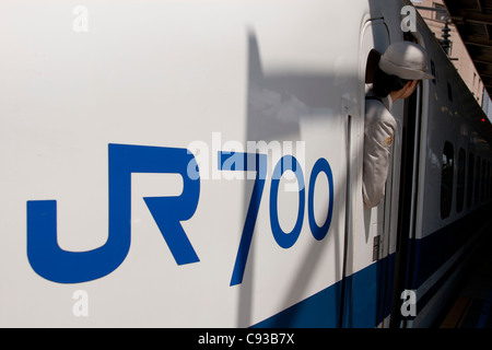 Eine weibliche Wache schaut aus einem shinkansen (Hochgeschwindigkeitszug) der Klasse 700 am Bahnhof Shin-Yokohama, Yokohama, Japan. Stockfoto