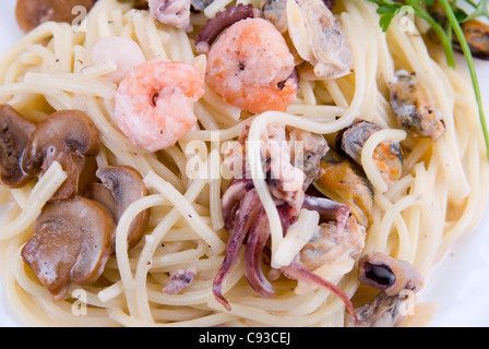 Spaghetti mit Meeresfrüchten und Champignons auf weißen Teller Stockfoto