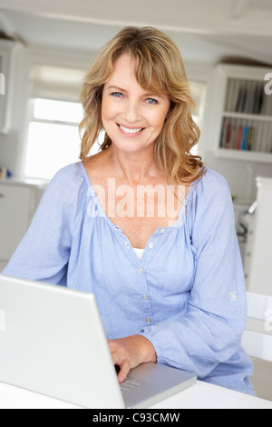 Mitte Alter Frau mit Laptop Stockfoto