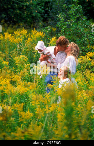 Vierköpfige Familie im Gebiet der wilden gelben Blüten in Schweden Stockfoto