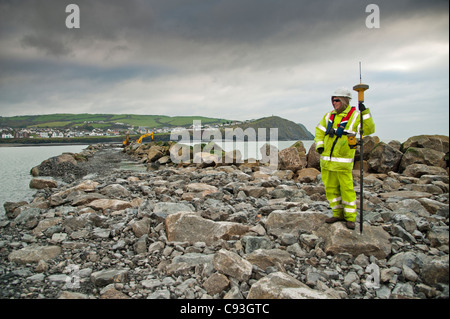 Ein Arbeiter halten ein GPS-Gerät während des Baus des neuen künstlichen Riff, Abwehrkräfte Teil des Meeres bei Borth Ceredigion Wales UK Stockfoto