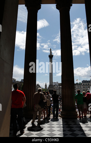 Touristen am Trafalgar Square in London, England. Blick von der National Gallery. Stockfoto