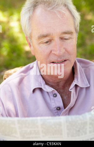 Senior woman lesen Zeitung im freien Stockfoto