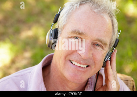 Senior woman anhören von Musik im freien Stockfoto