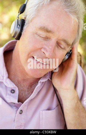 Senior woman anhören von Musik im freien Stockfoto