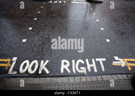 Blick rechts Warnung gemalt auf Straße in eine Fußgängerzone Zebrastreifen in London, Vereinigtes Königreich Stockfoto