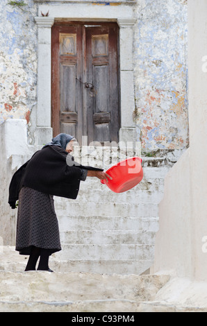 Alte griechische Frau, gekleidet in schwarz in der alten Chorio, Insel Symi, Griechenland Stockfoto