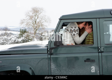 Junges Paar im Auto im Schnee Stockfoto