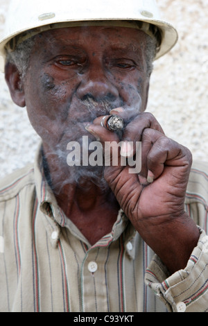 Alten kubanischen Arbeiter raucht eine kubanische Zigarre in Havanna, Kuba. Stockfoto