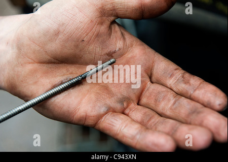 Überprüfen den Ölstand in einem Traktor-Motor, mit Messstab. Stockfoto