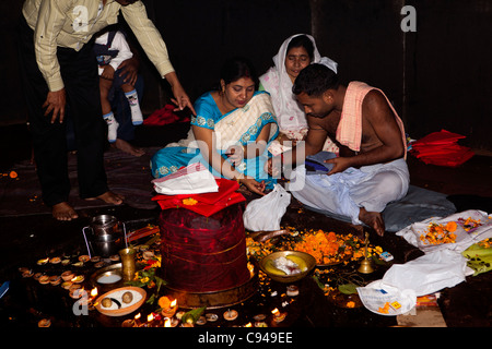 Indien, Assam, Guwahati, Navagraha Hill, Nabahraha Mandir, Gläubige und Hindu Priester am shivalingam Stockfoto