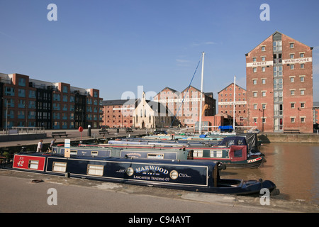 Gloucester Docks, Gloucestershire, England, UK. Regenerierte Victoria Dock mit Narrowboats und alten Lagerhäusern Stockfoto