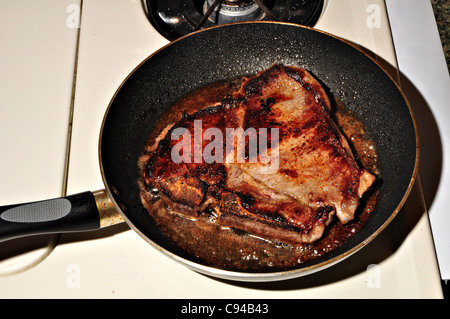 Ein t-Bone Steak ist das Kochen in einer Pfanne erhitzen. Stockfoto