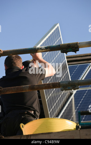 Großbritannien, England, Europa. Neue Solar-Panels auf einem Hausdach Montage Arbeiter Stockfoto