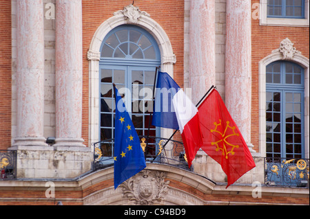 Flaggen der Stadt, die französische Trikolore und der Europäischen Union fliegen auf der Place du Capitole, Rathaus, Toulouse, Haute-Garonne, Frankreich Le Stockfoto