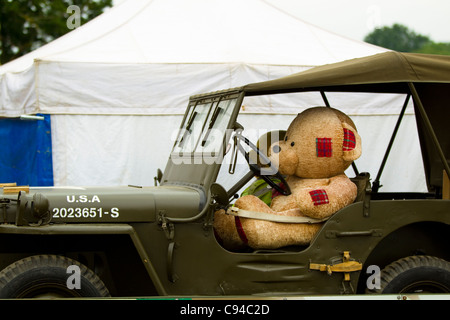 2 gefüllte Teddybären in einem Jeep 4 x 4. 1 in den Sitz anderen auf dem Beifahrersitz. Im Hintergrund ist ein weißes Zelt Stockfoto