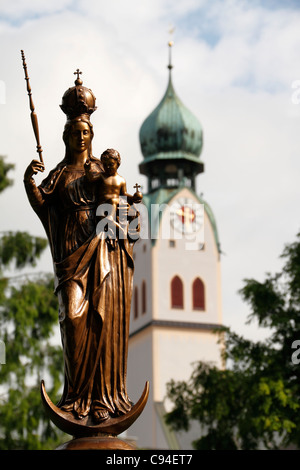 Mary Jesus-Figur mit der St. Nikolaus Kirche Kirchturm Glockenturm, obere Bayern Rosenheim Stockfoto