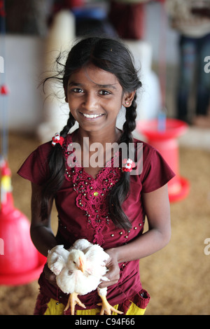 Mädchen hält ein Huhn in einer Geflügel Bauernhof Tamil Nadu, Indien Stockfoto