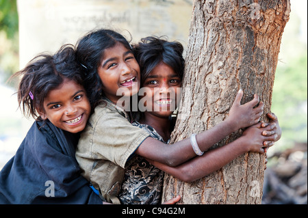 Armen indischen nomadischen Bettler Mädchen Lachen, während ein Baum und einander umarmen Stockfoto