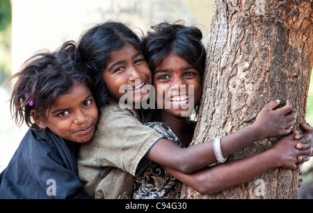 Armen indischen nomadischen Bettler Mädchen Lachen, während ein Baum und einander umarmen Stockfoto