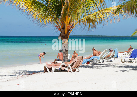 Kaukasische Touristen mit Sonnenbad auf Deck Chair (Tagesbett) am tropischen Strand von Türkis. Guardalavaca, Kuba Caribbean November 2010 Stockfoto