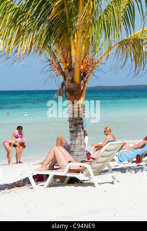 Kaukasische Touristen mit Sonnenbad auf Deck Chair (Tagesbett) am tropischen Strand von Türkis. Guardalavaca, Kuba Caribbean November 201 Stockfoto