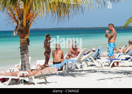 Kaukasische Touristen mit Sonnenbad auf Deck Chair (Tagesbett) am tropischen Strand von Türkis. Guardalavaca, Kuba Caribbean November 201 Stockfoto