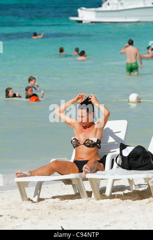 Schönen touristischen Frau (25 bis 30 Jahre) im Bikini, Sonnenbad am Tag Bett am Strand. Guardalavaca, Kuba, Caribbean November 2010 Stockfoto