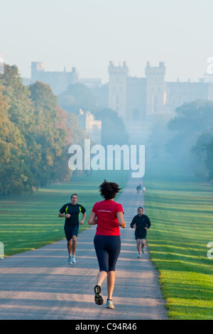 Jogger in den frühen Morgenstunden im Windsor Great Park, mit dem Schloss im fernen Nebel. VEREINIGTES KÖNIGREICH. Stockfoto