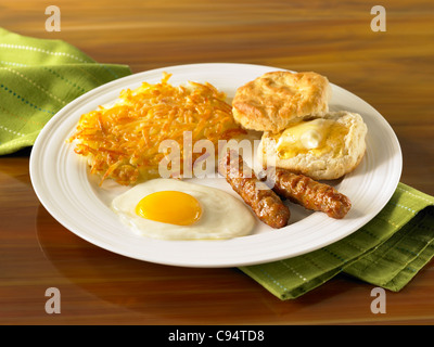 Ei-Frühstück mit Rösti, Wurst und Gebäck mit butter Stockfoto