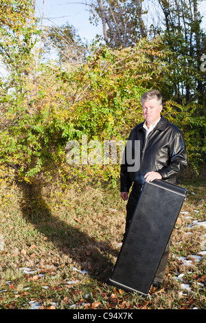 Ein Porträt des Musikers mit seinem Gitarrenkoffer Stockfoto