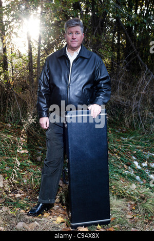 Ein Porträt des Musikers mit seinem Gitarrenkoffer Stockfoto