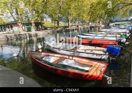 Kleine Boote vor Anker im Schatten der Bäume neben Quai Jules Philippe in Annecy Stockfoto