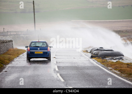 Sturm angetrieben Wellen über Landstraße am Deerness Orkney Festland, Schottland, UK. Stockfoto