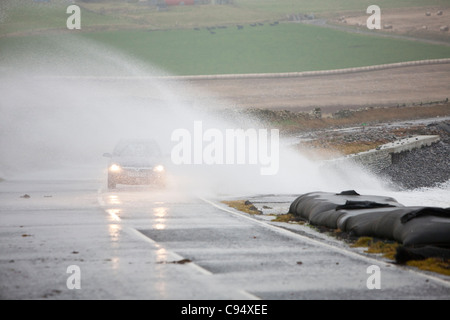 Sturm angetrieben Wellen über Landstraße am Deerness Orkney Festland, Schottland, UK. Stockfoto