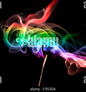 Wirbelnder mehrfarbiger Rauch von einem Joss-Stick auf einem Schwarzer Hintergrund Stockfoto