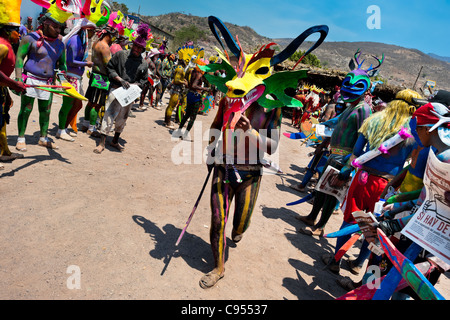 Ein Cora indischen Mann mit einem bunten Dämon Maske, Wanderungen während der heiligen Zeremonie der Heiligen Woche in Jesús María, Nayarit, Mexiko. Stockfoto