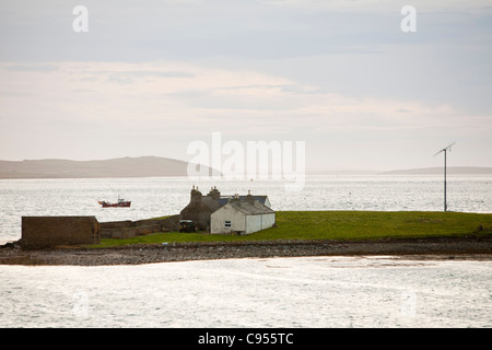 Einer kleinen Windkraftanlage Einschalten ein Haus am äußeren Holm Insel vor Stromness in Orkney, Schottland, Stockfoto