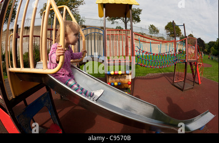 Ein kleines Kind auf einer Folie in einen Spielplatz Stockfoto