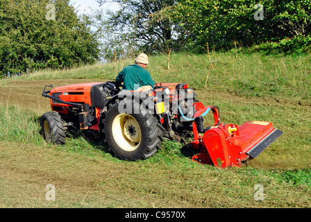 Kleiner Bauernhof Traktor Busch Beschlag auf einer Wiese in Trentino Alto Adige. Italien Stockfoto